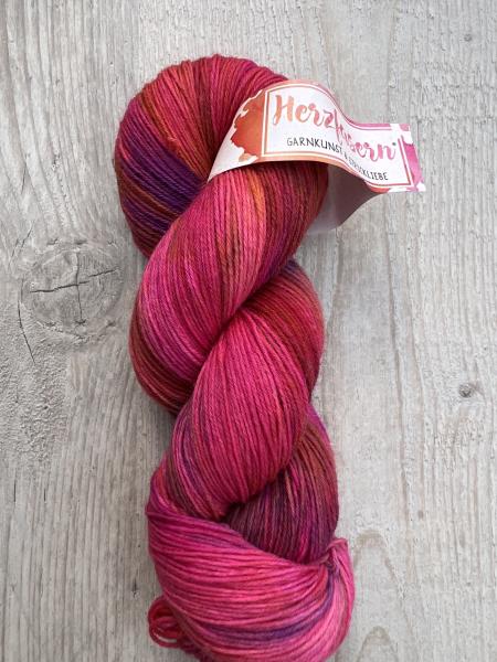 Dieses Garn wurde moeglichst farbecht fotografiert. Je nach Bildschirm koennen die Farben abweichen. Farbtoene in Worten beschrieben: kraeftiges Pink, Beerentoene, helle Rosaaufhellungen und leuchtende Highlights.  ALT-Texte fuer Screenreader: 	1.	Ein Str